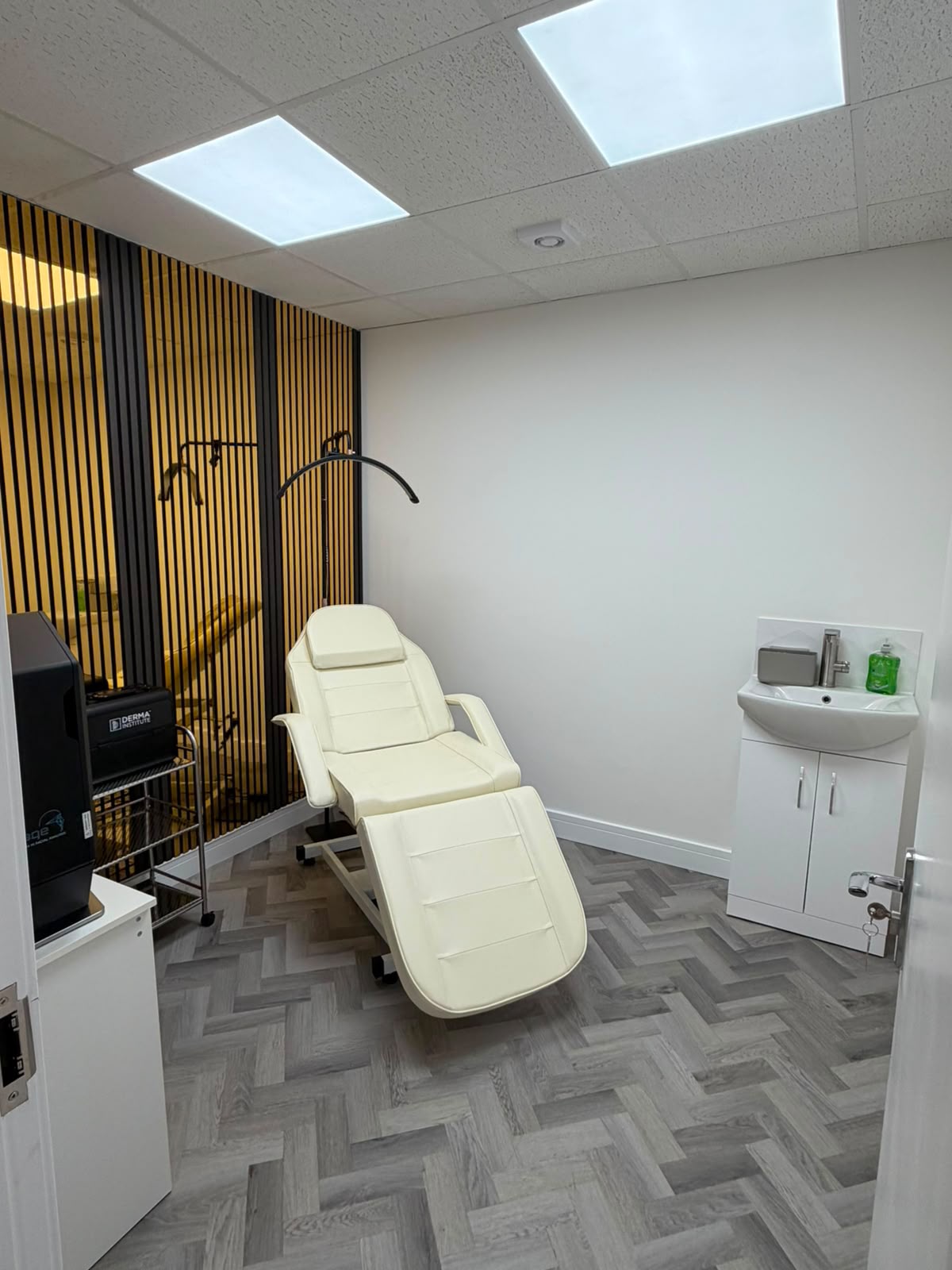 Treatment room with cream chair and gold accent wall